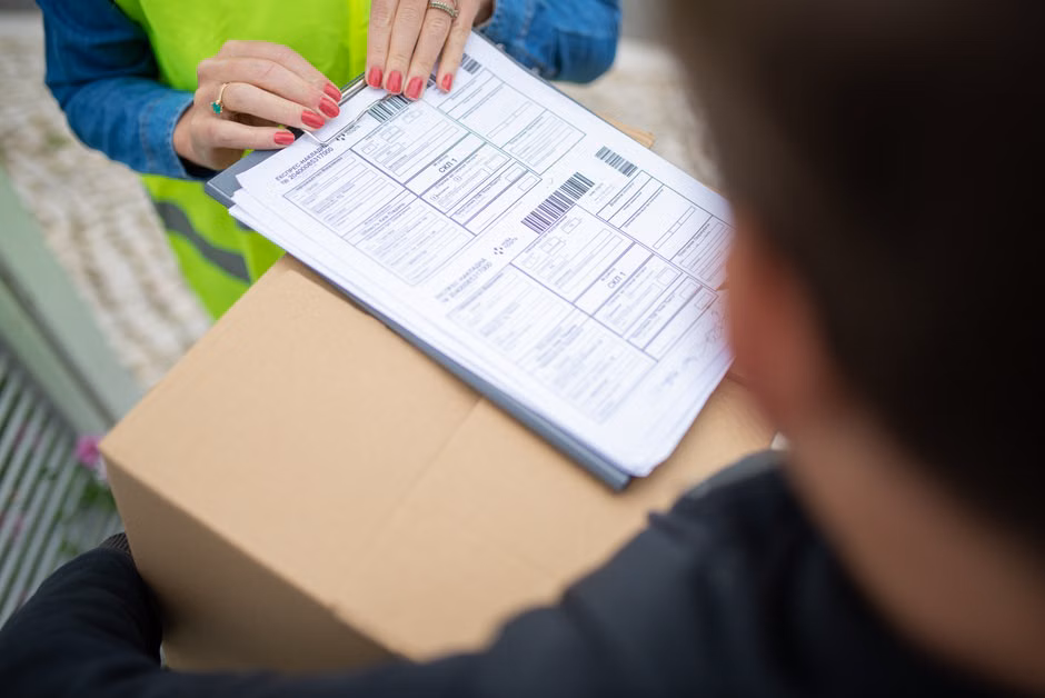 Courier hands over a package for delivery with signing of receipt documents, representing cross border shipping documentation.